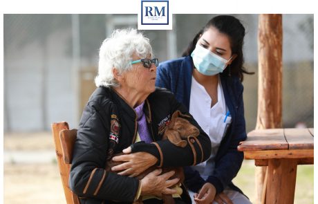 Une personne âgé étreint une chèvre